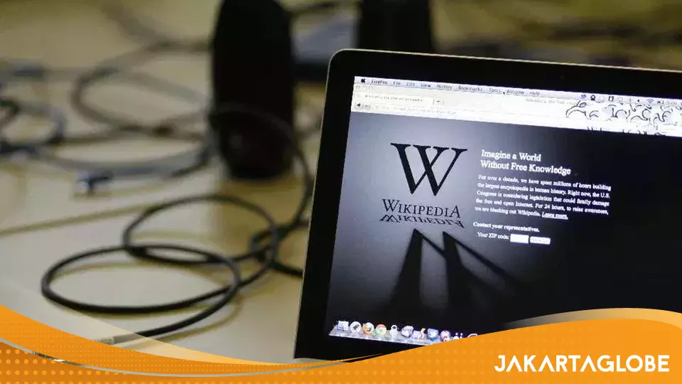 Ilustrasi logo Wikipedia pada layar komputer yang menandakan pemulihan akses