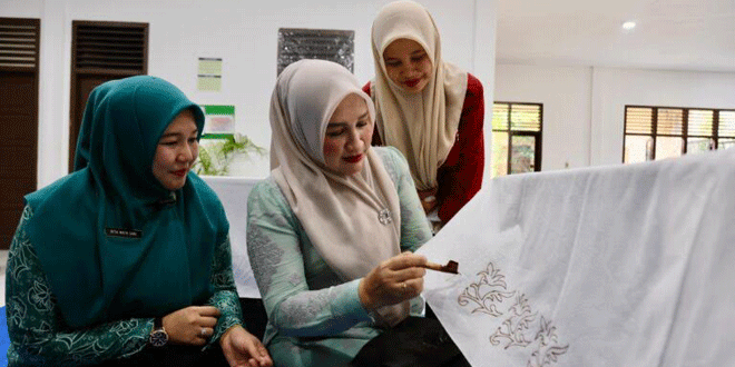 Marlina Muzakir menyerahkan canting batik dan mesin tenun kepada perajin di Aceh Besar