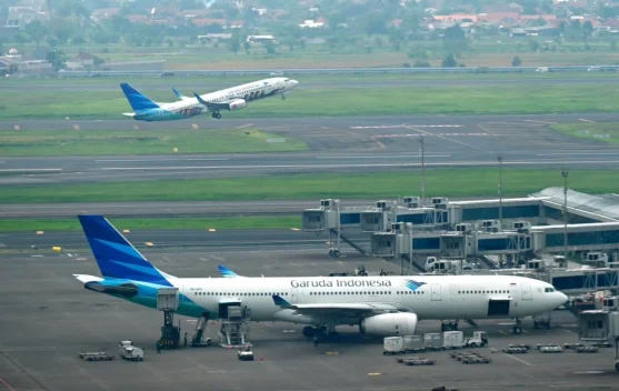 Ilustrasi pesawat dan wisatawan, dampak kenaikan fuel surcharge