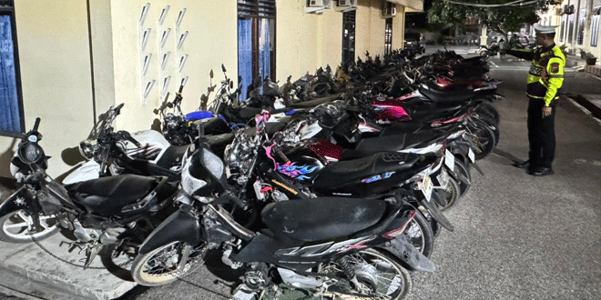 Petugas polisi memeriksa motor yang menggunakan knalpot brong saat operasi tilang di Panyabungan