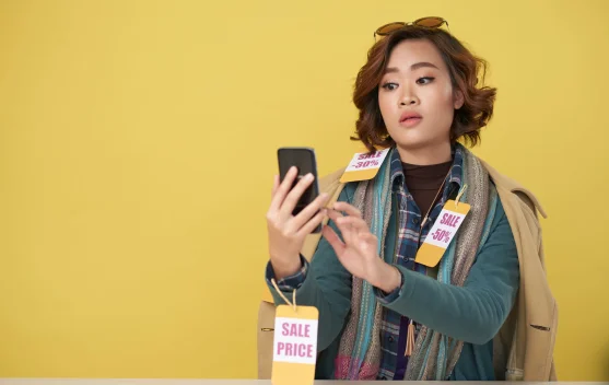 Mahasiswa memegang ponsel dan dompet saat belanja online hemat