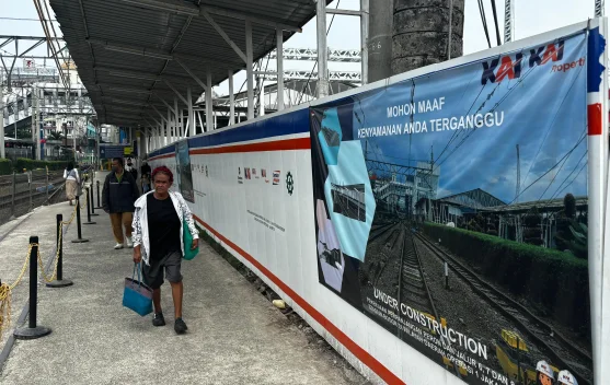 Pekerja melakukan perpanjangan peron dan pemasangan tiang LAA di Stasiun Bogor
