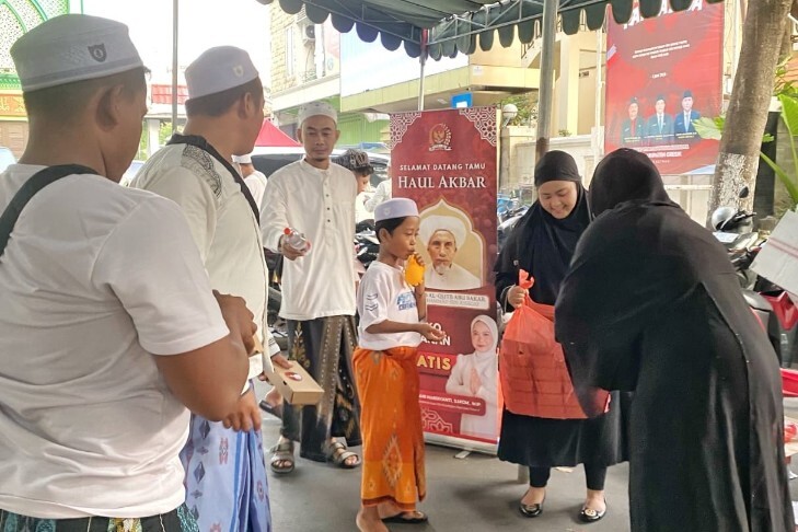 Relawan membagikan makanan gratis kepada jamaah Haul Habib Abu Bakar Assegaf di Gresik