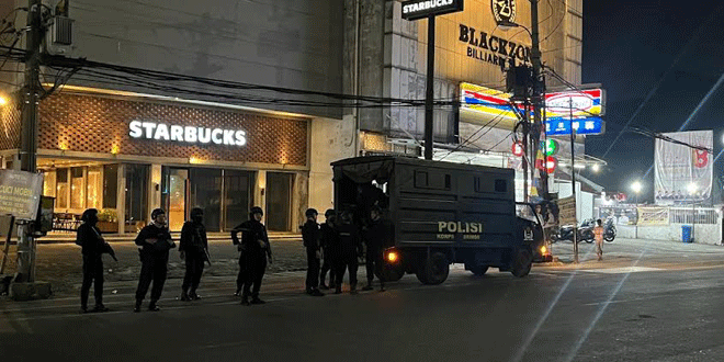 Personel Brimob melakukan patroli malam di jalan kota Medan