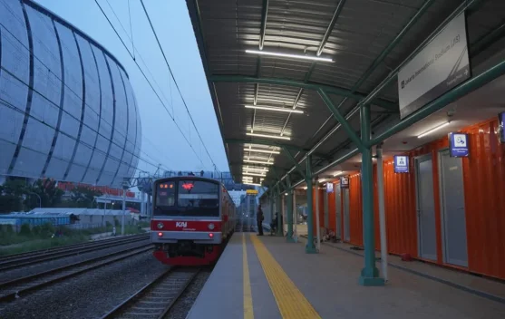 Kereta Commuter Line berhenti di Stasiun Jakarta International Stadium dengan penumpang menunggu