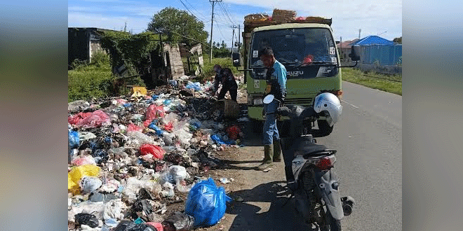 Petugas DLH Aceh Besar membersihkan tumpukan sampah di Jalan Blang Bintang Lama