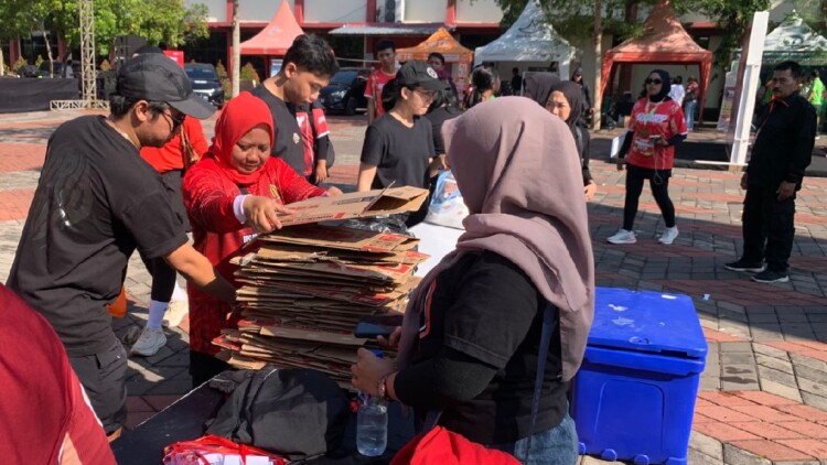 Relawan memunguti sampah pasca lomba lari di Jember