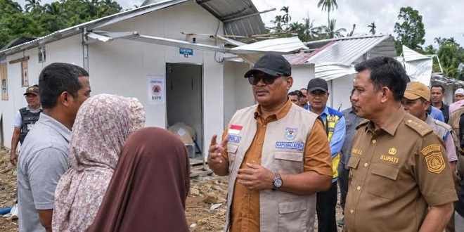 Tumpukan kayu hanyut di tepi sungai pascabanjir di Aceh