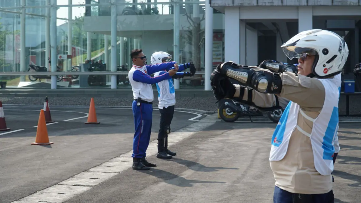 Pengendara motor melakukan peregangan singkat sebelum berkendara