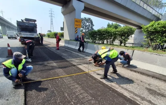 Petugas Jasa Marga melakukan perbaikan permukaan jalan tol malam hari menjelang libur sekolah