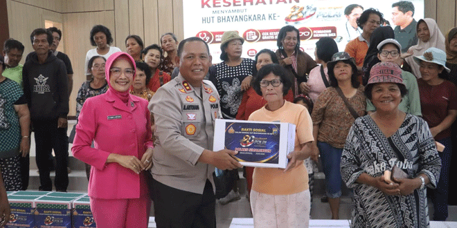 Kapolres Marganda Aritonang menyerahkan bingkisan kepada warga saat Bakti Kesehatan dan Bakti Sosial Polres Simalungun