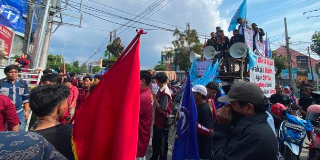 Massa aksi demonstrasi di depan kantor PLN UID Sumut dengan ban dibakar dan pagar rusak