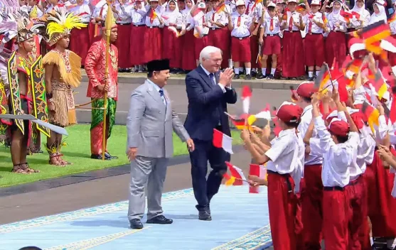 Presiden Prabowo dan Presiden Steinmeier melambaikan tangan kepada pelajar di halaman Istana Merdeka
