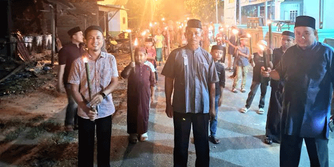 Warga membawa obor malam hari dalam pawai menyambut Tahun Baru Hijriah di Kisaran