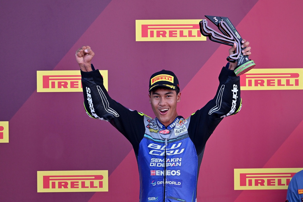Aldi Satya Mahendra di podium World Supersport Misano 2026 mengibarkan Merah Putih