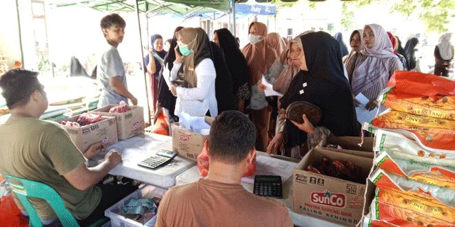 Warga antre untuk membeli paket Gerakan Pangan Murah di halaman Kantor Camat Simpang Tiga