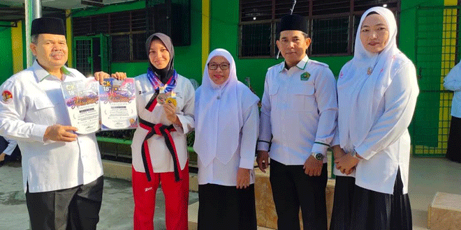 Zaskia Zafhira memegang medali juara di MTsN 3 Medan