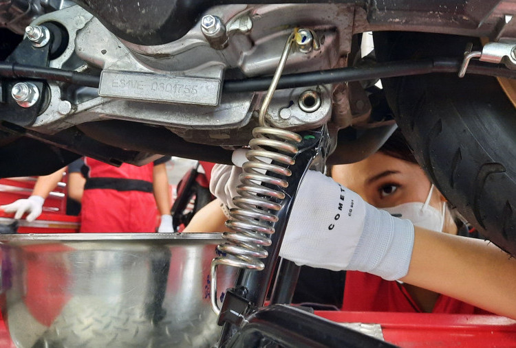 Motor di bengkel dengan mekanik memeriksa filter udara pada musim kemarau