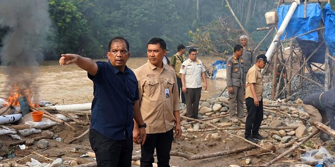 Bekas galian dan peralatan tambang di tepi Sungai Batang Gadis akibat PETI di Mandailing Natal