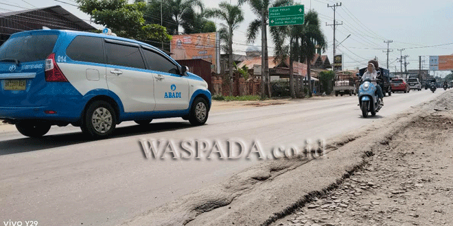 Pengendara menghindari badan jalan nasional yang bergelombang di Desa Firdaus, Sei Rampah