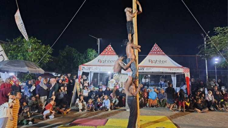 Warga Desa Kedungsigit mengikuti lomba panjat pinang saat Bersih Desa malam hari