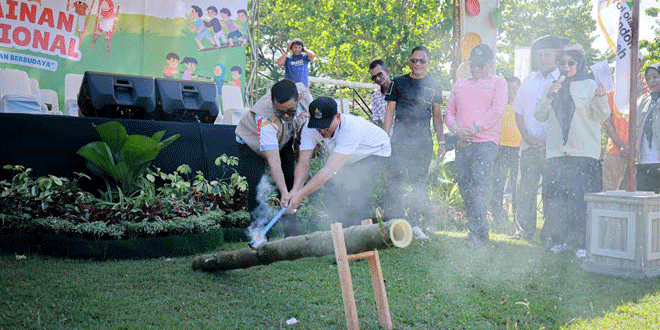 Asisten III menyerahkan hadiah pada pemenang tarek situek saat festival permainan tradisional
