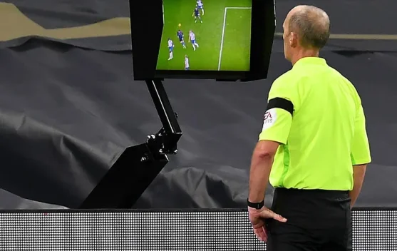Ilustrasi wasit menggunakan VAR di pinggir lapangan stadion