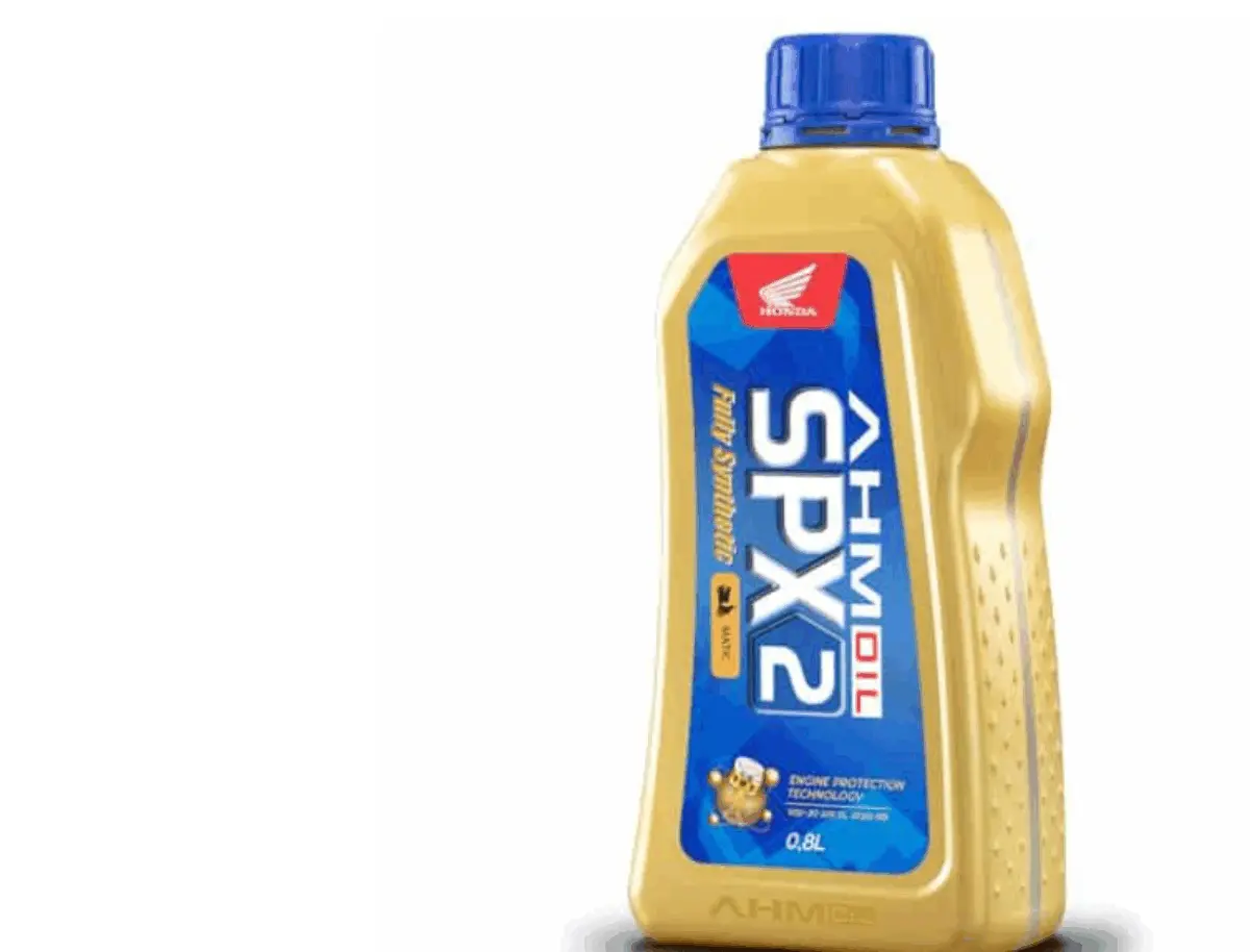 Botol oli motor matic di atas lantai garasi