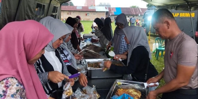 Personel Brimob menyalurkan makanan kepada warga terdampak puting beliung di Medan Johor
