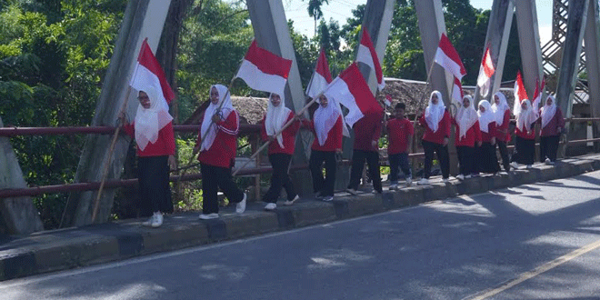 Anggota TP PKK Seulimeum memasang bendera Merah Putih di Jembatan Krueng Inong, Jantho