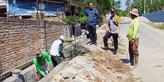 Bhabinkamtibmas dan lurah memeriksa parit serta drainase di Jalan Manunggal Karya