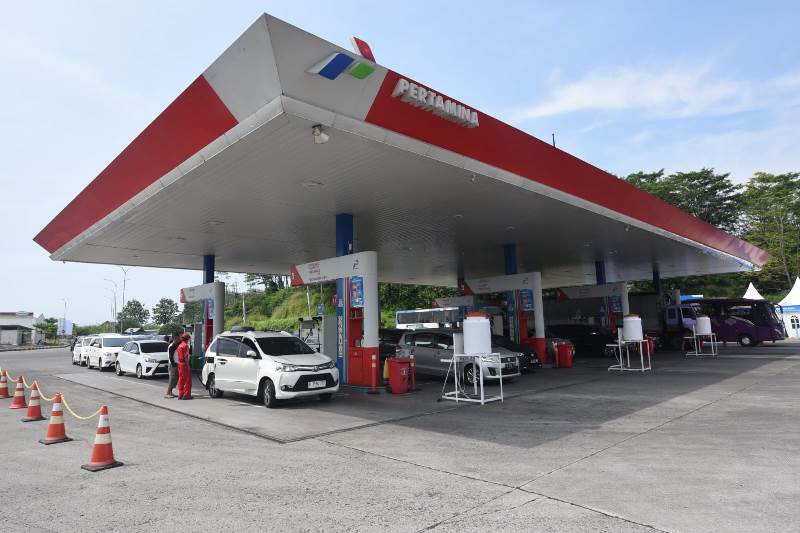 Ilustrasi pom bensin Pertamina dan papan harga BBM per liter