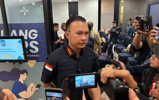 Petugas imigrasi memeriksa dokumen penumpang di pintu keberangkatan