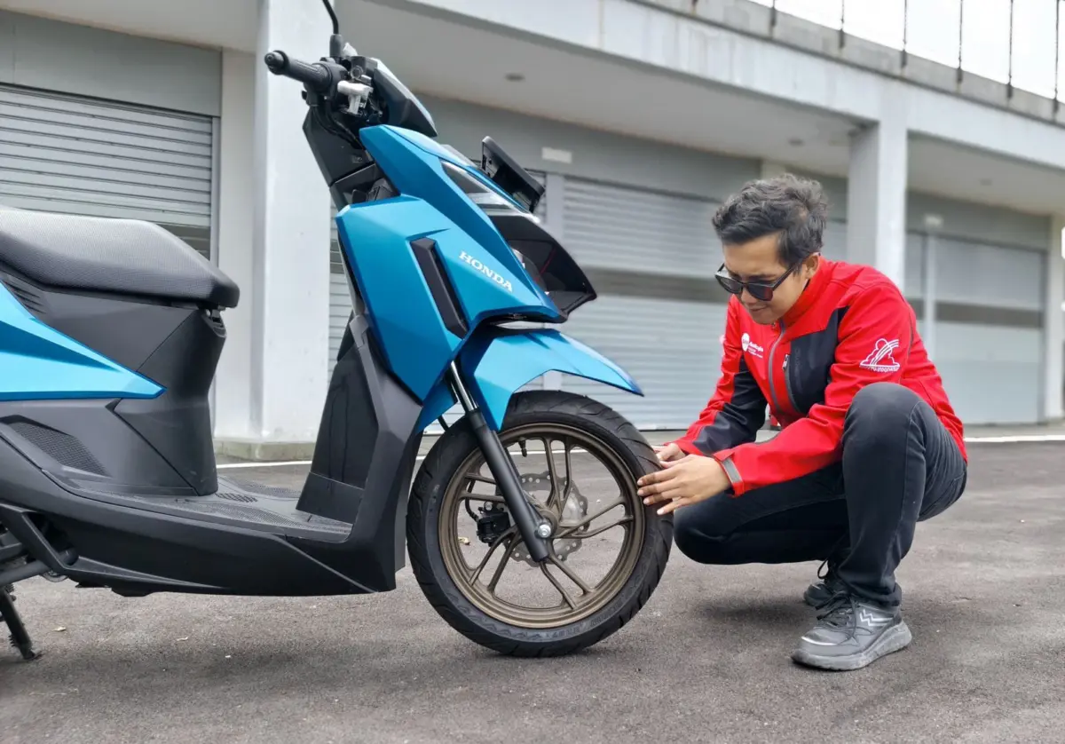 Motor diparkir di standar tengah dengan cover untuk perlindungan