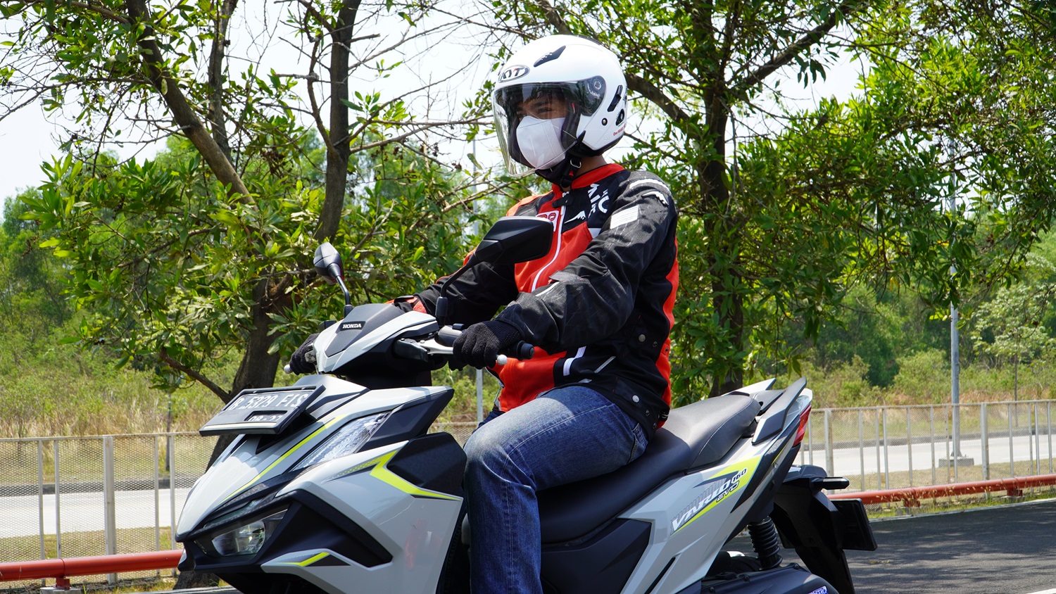 Pengendara menggunakan helm dan masker saat hujan abu vulkanik mengganggu jalan