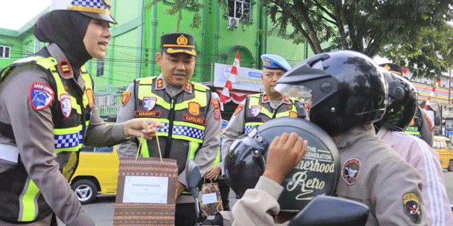 Kapolres Langkat membagikan bingkisan kepada pengendara tertib di Stabat