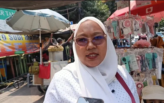 Warga membersihkan abu vulkanik di teras rumah sambil menggunakan masker