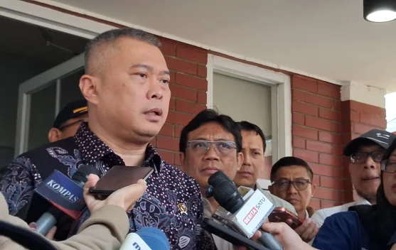 Penumpang menunggu informasi jadwal penerbangan di terminal bandara