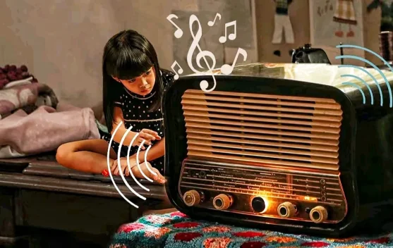 Poster film Na Willa menampilkan anak kecil mendengarkan radio tua