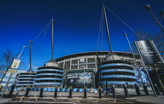 Logo Manchester City di depan stadion Etihad, menggambarkan klub dalam sorotan soal dakwaan finansial