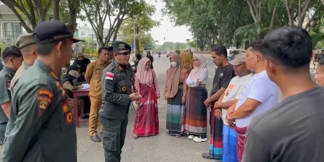 Petugas Satpol PP/WH memberi pembinaan dan membagikan sarung kepada pelanggar busana di Lhokseumawe