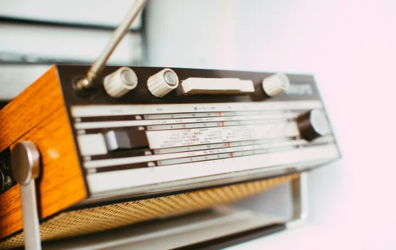 Ilustrasi radio tua dan gelombang siaran menggambarkan sejarah penyiaran Indonesia