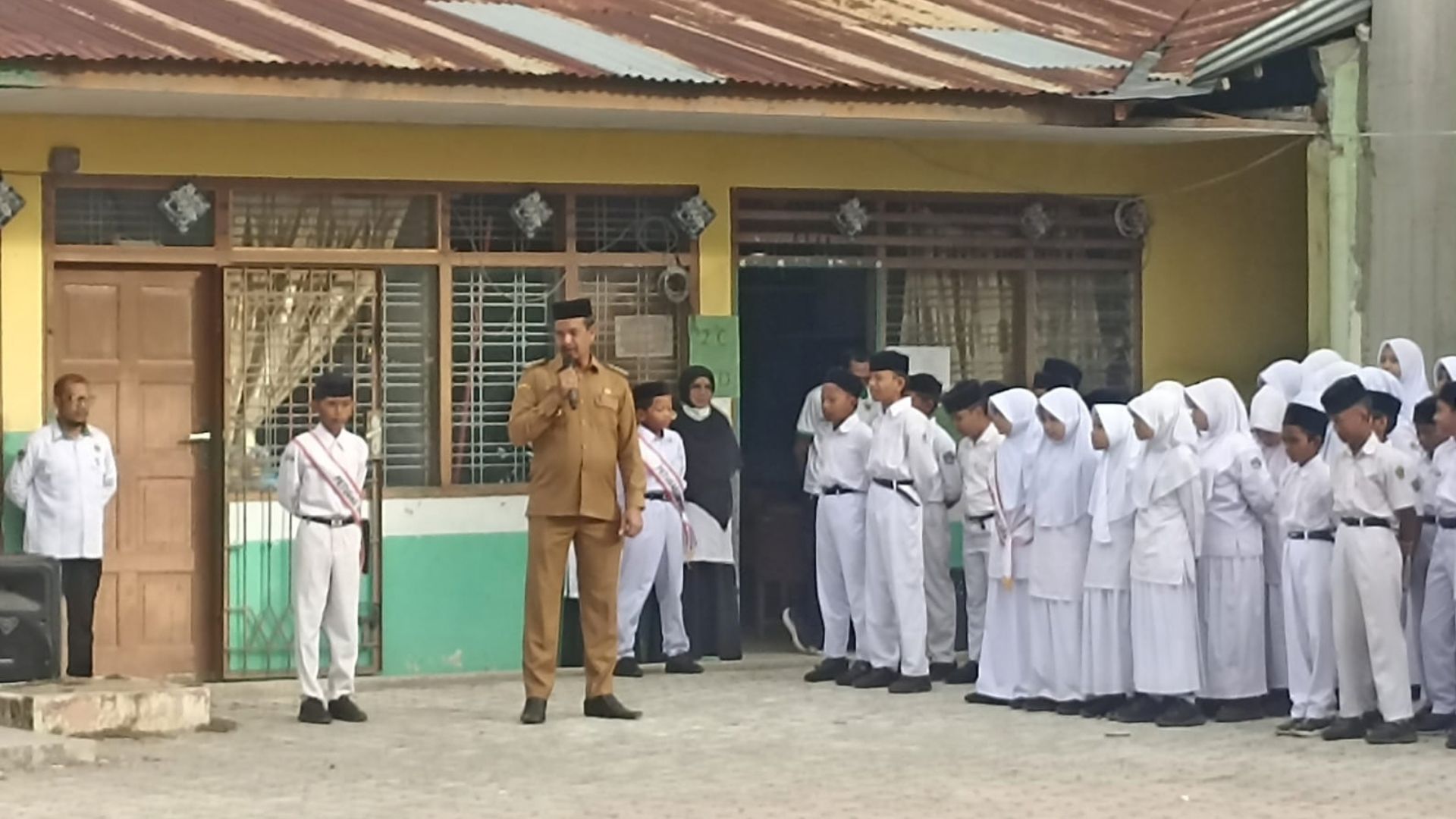 Camat Zahrul Fuadi memimpin upacara dan memberikan santunan di MIN 25 Aceh Besar