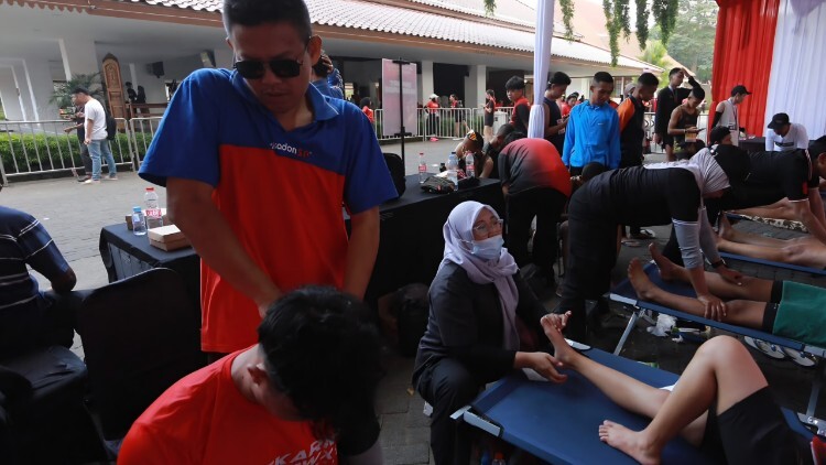 Terapis disabilitas netra memberikan sport massage kepada pelari di Soekarno Run BWX 2026