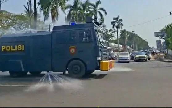 Personel Polri dan water cannon menyemprot jalan untuk mengurangi endapan abu Anak Krakatau