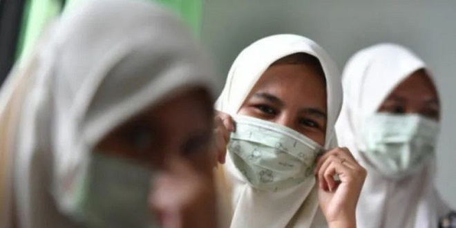 Siswa dan guru memakai masker di halaman sekolah karena kualitas udara di Medan
