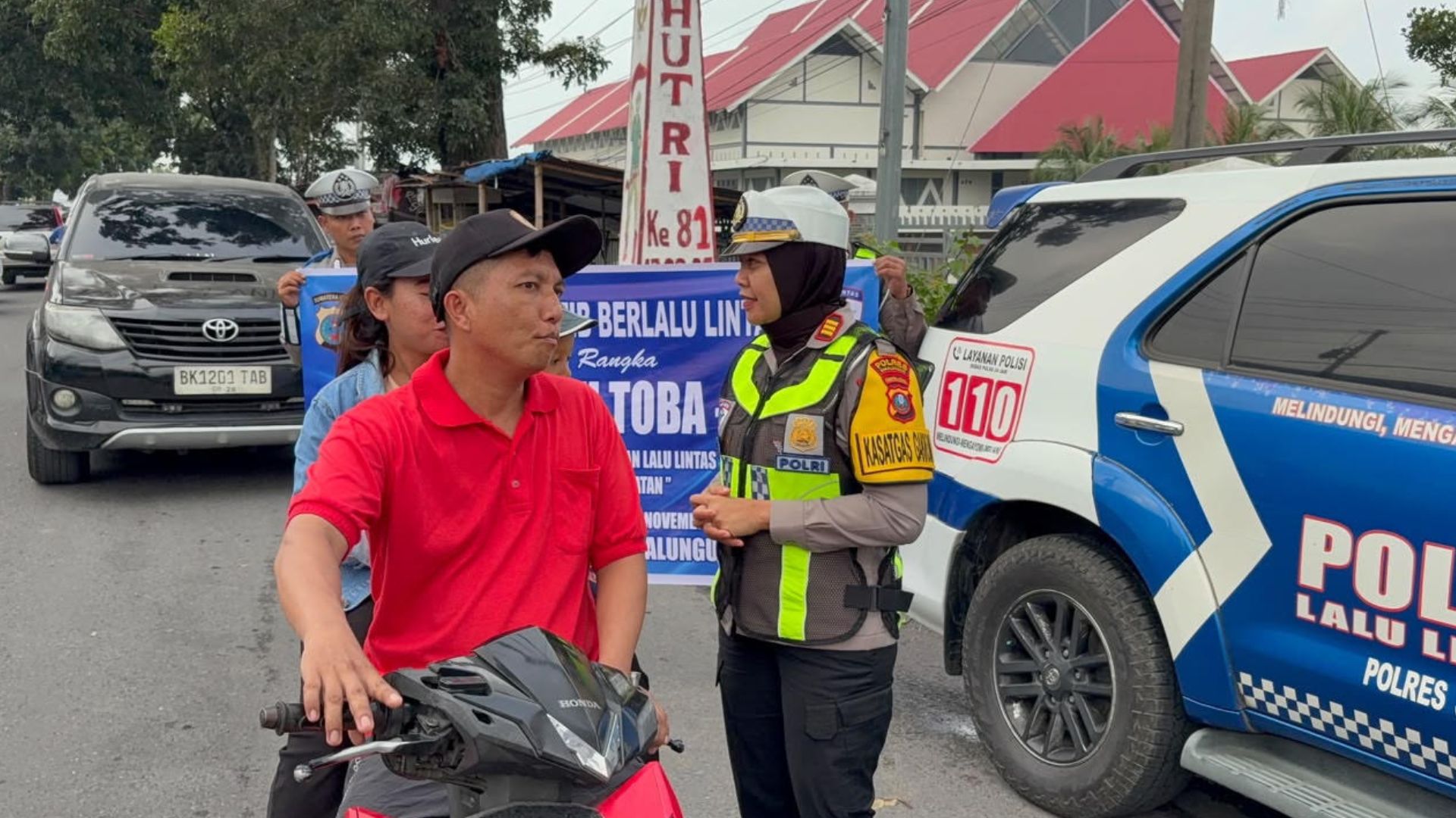 Personel Satlantas Polres Simalungun membagikan stiker dan brosur Operasi Patuh Toba 2026