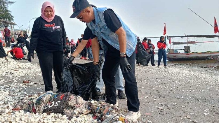 Peserta Merah Muda Fest membersihkan pantai Kenjeran sebagai aksi lingkungan