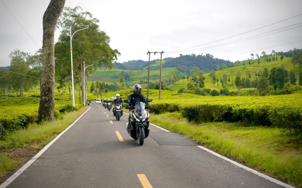 Pengendara sepeda motor berhati-hati menyalip truk di jalan raya
