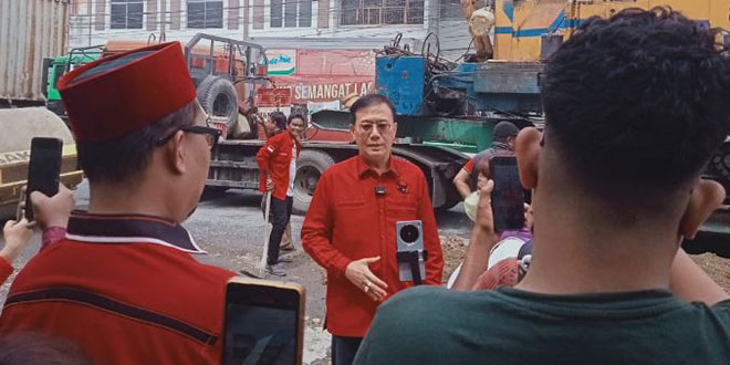 Warga melakukan penimbunan jalan rusak di Jalan KL Yos Sudarso